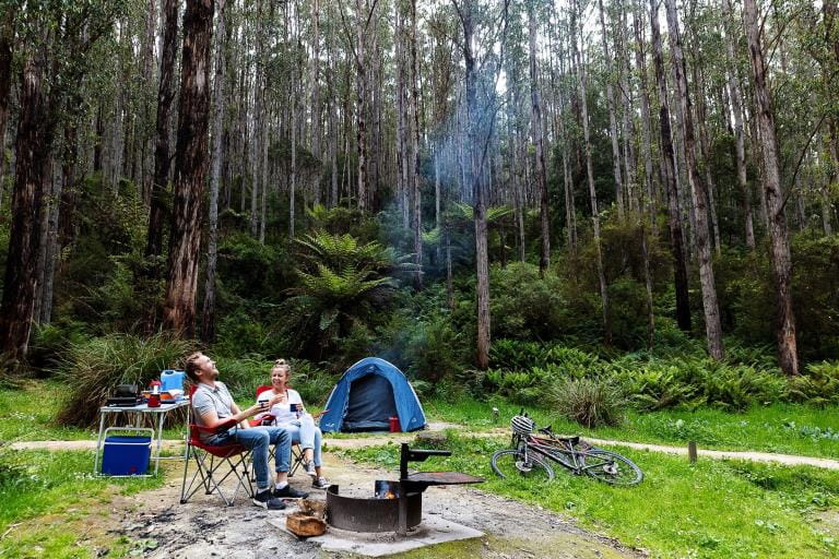 A couple relax at their campsite in the Victorian bush.
